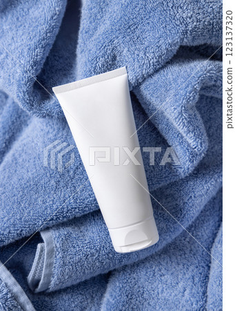 White blank squeeze cream tube on blue bath towel top view, mockup. Natural handmade cosmetic 123137320