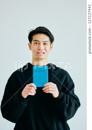 A young man in his 20s holding a pension book 123137441