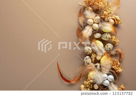 Easter composition with quail eggs, feathers, and dried flowers. 123137782