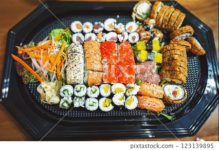 A large set of sushi rolls with shrimp, salmon, tuna, eel in plastic packaging on a white background, top view. Sushi delivery A large set of sushi rolls with shrimp, salmon, tuna, eel in plastic packaging on a white background, top view. Sushi delivery 123139895