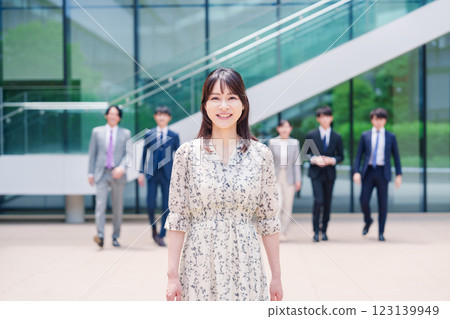 Smiling career woman and her colleague walking outside the office 123139949