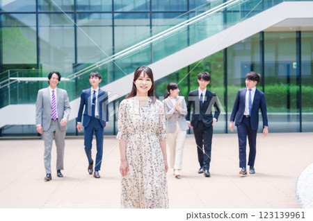 Smiling career woman and her colleague walking outside the office 123139961