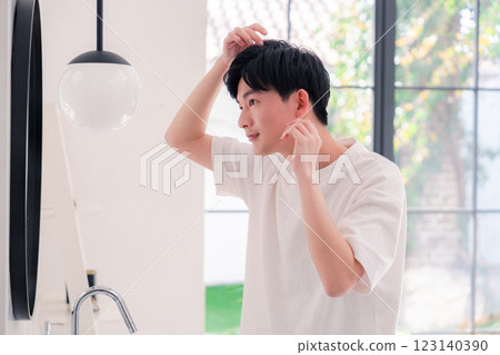 一名年輕男子在浴室梳洗 123140390