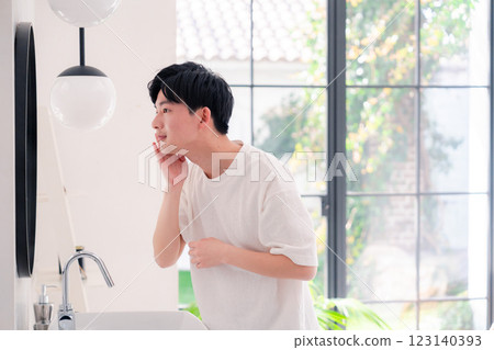 一名年輕男子在浴室梳洗 123140393