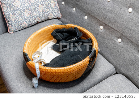 The beginning of the process of knitting a black sweater in a basket. 123140553