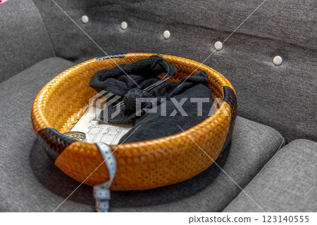 The beginning of the process of knitting a black sweater in a basket. 123140555