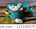 Raw dumplings in a blue bowl on a wooden background. 123140570