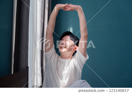 A young man waking up refreshed in the morning sun 123140657