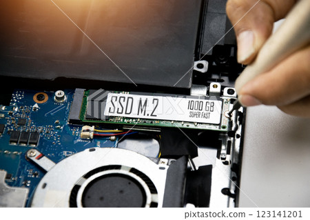 Technician is installing M.2 SSD onto motherboard. 123141201