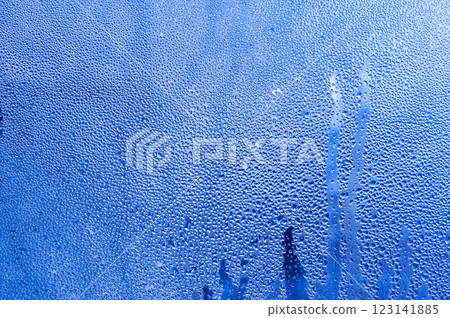 Background condensation of water on the window glass due to high humidity. the gradient of the blue background of wet glass. 123141885