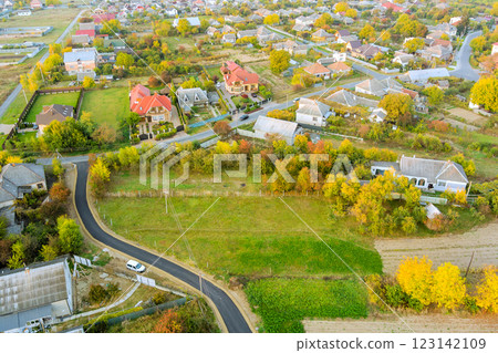Suburban homes, winding road are nestled among colorful autumn foliage in serene rural setting. Suburban homes, winding road are nestled among colorful autumn foliage in serene rural setting. 123142109
