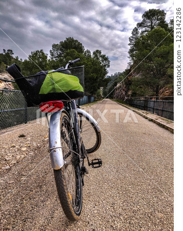 Bicycle on Scenic Trail with Green Basket and Trees 123142286