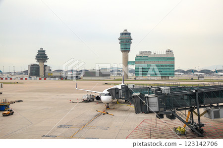 Airport baggage tug (baggage dolly transport) on duty and Ground Service fuel truck Refueling an aircraft at aircraft bay. Airport baggage tug (baggage dolly transport) on duty and Ground Service fuel truck Refueling an aircraft at aircraft bay. 123142706