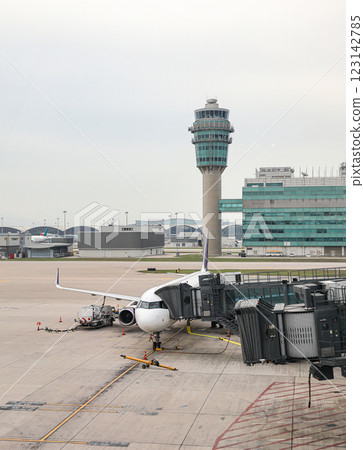 Airport baggage tug (baggage dolly transport) on duty and Ground Service fuel truck Refueling an aircraft at aircraft bay. 123142785