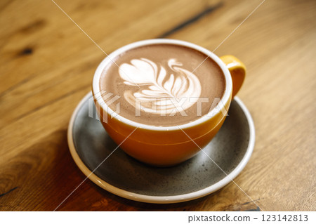 Cup of cocoa with milk art on wooden table in the morning at breakfast Cup of cocoa with milk art on wooden table in the morning at breakfast 123142813