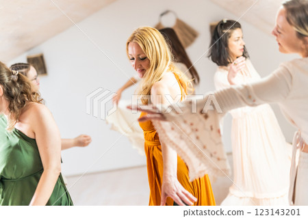 Group of cheerful women all ages, happy people dancing together wearing traditional colorful dresses and hippy clothes. Free people enjoying leisure activity, emphasizing friendship, fun, movement. Group of cheerful women all ages, happy people dancing together wearing traditional colorful dresses and hippy clothes. Free people enjoying leisure activity, emphasizing friendship, fun, movement. 123143201