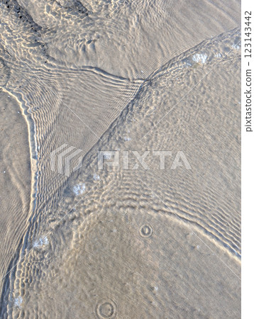 Rippling Water on Sandy Shore Background 123143442