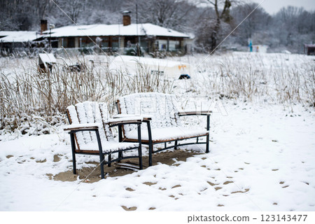 Winter landscape with benches in a fishing village on the seashore - selective focus 123143477