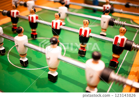 Tabletop football game with red and white player figures on green field 123143826