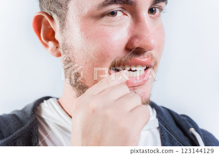 Close up of man with dermatophagia, biting his nails. Person biting nails isolated Close up of man with dermatophagia, biting his nails. Person biting nails isolated 123144129