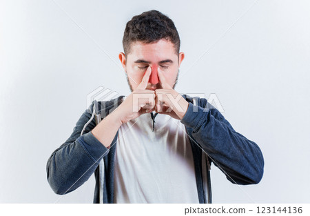 Suffering man with nasal congestion isolated. Sore person suffering with nasal bridge on isolated background Suffering man with nasal congestion isolated. Sore person suffering with nasal bridge on isolated background 123144136