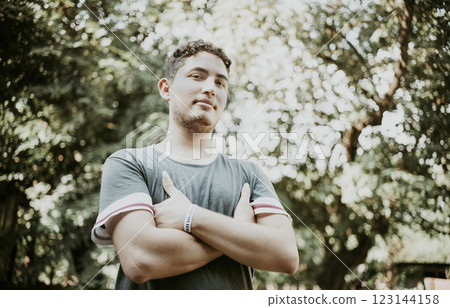 Latin American man with crossed arms smiling at camera. Portrait of handsome latin guy outdoors 123144158