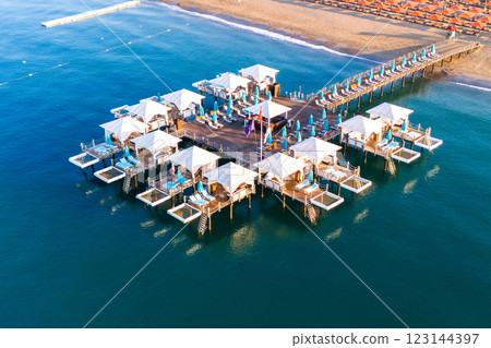 Aerial view of a luxury beach resort with exclusive overwater cabanas on a wooden pier. Aerial view of a luxury beach resort with exclusive overwater cabanas on a wooden pier. 123144397