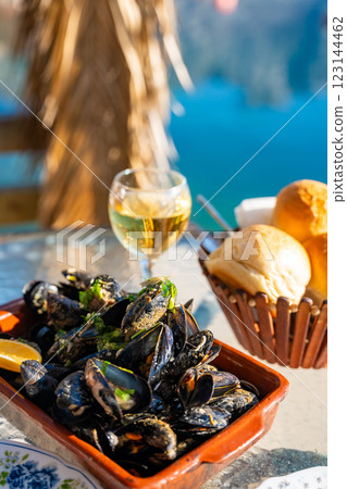 Mussels and white wine in a restaurant with a sea view in oyster farm of Kotor Bay, Montenegro Mussels and white wine in a restaurant with a sea view in oyster farm of Kotor Bay, Montenegro 123144462