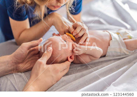 A newborn baby receives gentle osteopathic care, lying calmly while the specialist carefully examines and adjusts the infant. A moment of professional pediatric care, early development, and holistic 123144560