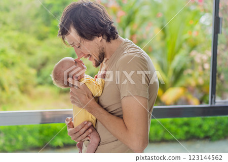 A father gently embraces his newborn baby near a window, bathed in soft natural light. A heartwarming moment of love, protection, and deep connection, symbolizing the beauty of fatherhood and new 123144562