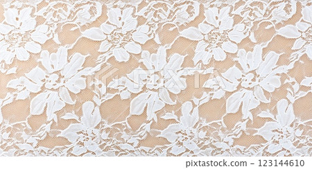 Elegant white floral lace pattern on beige fabric background. 123144610