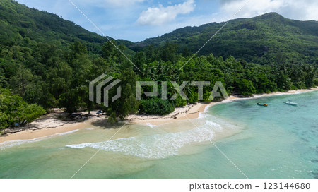 Beach with turquoise waters and lush greenery, surrounded by hills and clear skies. Seychelles, Mahe. Anse Marie Louise. Beach with turquoise waters and lush greenery, surrounded by hills and clear skies. Seychelles, Mahe. Anse Marie Louise. 123144680