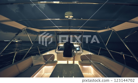 Male captain navigating yacht at night through stormy seas under dark sky 123144702