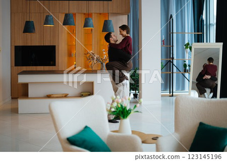 Couple enjoying a joyful moment in a modern living room setting Couple enjoying a joyful moment in a modern living room setting 123145196