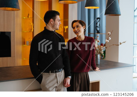 Couple sharing a joyful moment in a modern interior setting Couple sharing a joyful moment in a modern interior setting 123145206