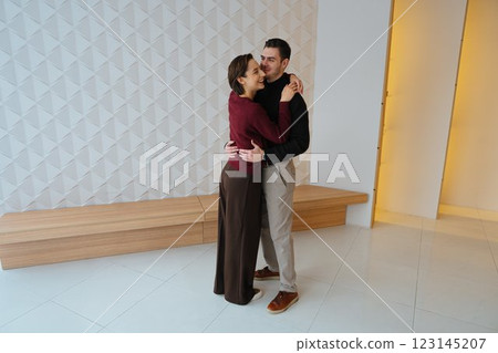 Couple dancing gracefully in a stylish indoor space at sunset Couple dancing gracefully in a stylish indoor space at sunset 123145207