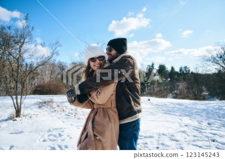 Couple enjoys a winter day together in a snowy landscape Couple enjoys a winter day together in a snowy landscape 123145243