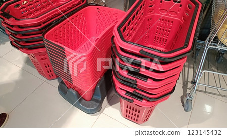 A collection of stacked red shopping baskets neatly organized in a retail store setting A collection of stacked red shopping baskets neatly organized in a retail store setting 123145432