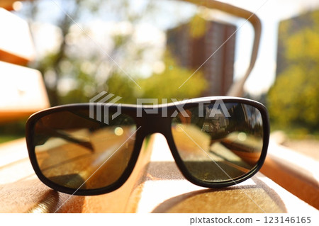 Black sunglasses on a wooden bench Black sunglasses on a wooden bench 123146165