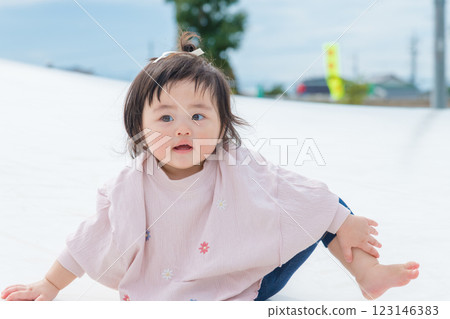 [Infants sitting on giant playground equipment] 123146383
