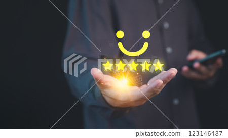 Person holding a glowing five-star customer review with a smile face, symbolizing high-quality service and positive customer satisfaction in online shopping, background features shopping cart icons. Person holding a glowing five-star customer review with a smile face, symbolizing high-quality service and positive customer satisfaction in online shopping, background features shopping cart icons. 123146487