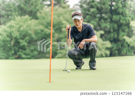 男高爾夫球手在高爾夫球場綠地上閱讀台詞 男高爾夫球手在高爾夫球場綠地上閱讀台詞 123147166