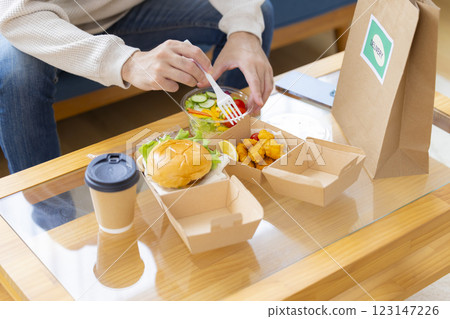 一名男子正在吃外送服務訂購的食物 123147226