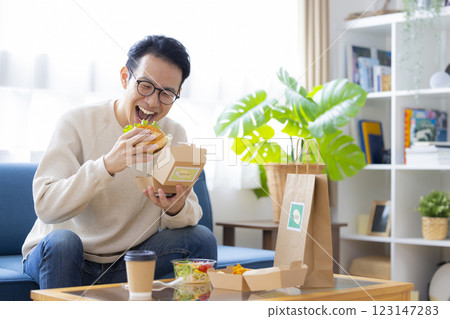 A man eating food he ordered via delivery service 123147283