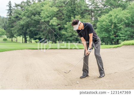 Male golfer hitting a bunker shot 123147369