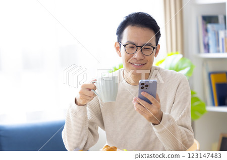 一名男子邊吃邊看智慧型手機 123147483