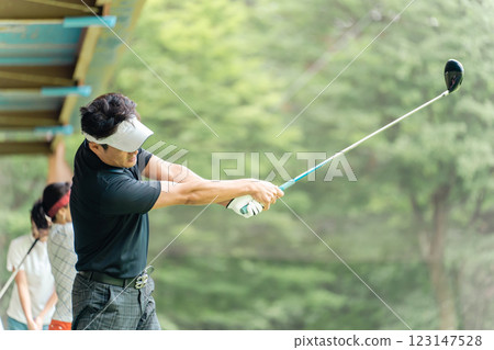 高爾夫練習場、擊球、高爾夫球手在高爾夫中心練習揮桿、男女高爾夫球手 123147528