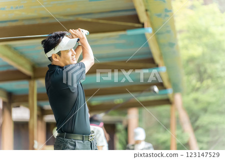 高爾夫練習場、擊球、高爾夫球手在高爾夫中心練習揮桿、男女高爾夫球手 123147529