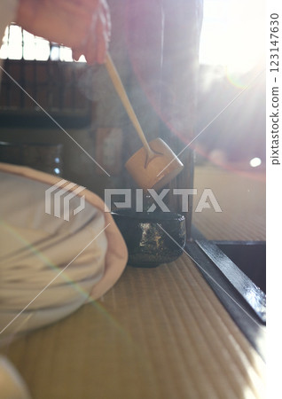 一位身著和服的女子正在往黑色茶杯裡倒熱水 一位身著和服的女子正在往黑色茶杯裡倒熱水 123147630