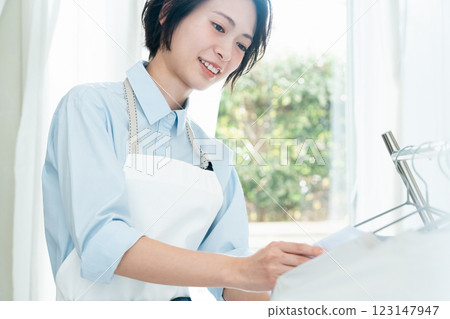 A woman hanging laundry to dry indoors 123147947